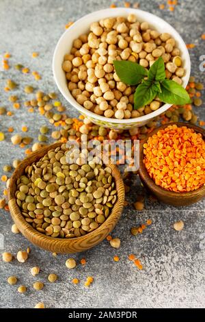 Gesunde Ernährung, Ernährung, Konzept vegane Proteinquelle. Rohstoff von Hülsenfrüchten (Kichererbsen, rote Linsen, kanadische Linsen). Stockfoto