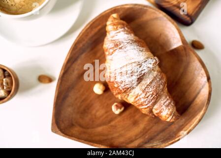 Kaffee und Croissant auf hölzernen Tisch. Französisches Frühstück. Ansicht von oben flach mit Platz für Ihren Text kopieren Stockfoto