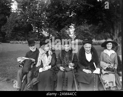 Archiv Edwardian-Bild um 1910 von fünf älteren Menschen, die in einem Park sitzen und direkt von einem Glasnegativ gescannt wurden. Stockfoto