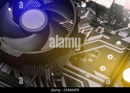 Hauptplatine des Computers. Das Kühlsystem des Prozessors auf dem Computer. Kühler mit einem Lüfter auf der Hauptplatine. Elektronische Leiterplatte schließen. Stockfoto