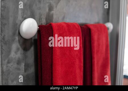 Zwei rote Handtücher im Badezimmer auf einem Trockner. Counter Bad modern. Luxuriöses und elegantes Design Badezimmer mit einem konkreten Mauern. Stockfoto