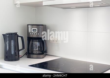 Das Kücheninnere mit Elektrogeräten, Kapuze, kettler, Kaffeemaschine und Herdplatten Stockfoto