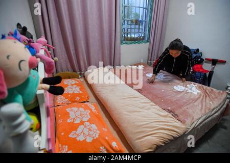 (200111) - CHANGSHA, Jan. 11, 2020 (Xinhua) - Xiang Mei macht das Bett an ihrem Haus am Umzug Website in Pinglang Dorf Jishou Stadt Xiangxi der Tujia und Miao Autonomen Präfektur, die Zentrale China Provinz Hunan, Jan. 8, 2020. Die Familie von Xiang Mei hat sich Armut erschüttert und ein neues Leben begonnen, seit sie aus der Bergregion verschoben und Umgesiedelt in neue Residenz mit besseren natürlichen Umgebungen und Lebensbedingungen bei Pinglang Dorf während der lokalen Verschiebung Programme für arme Dorfbewohner Ende 2017. Xiang, 34, gewann sie ihren ersten Job als Putzfrau hier. Und zusammen mit Stockfoto