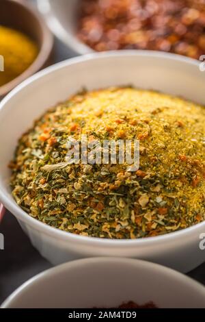 Vegeta und verschiedene Gewürze und Kräuter in Schalen. Trockenes Gemüse mit Salz und Kräutern Stockfoto