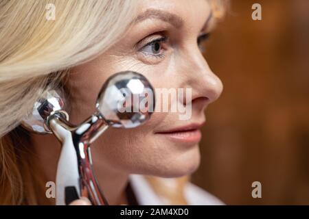Reife Frau, die selbst ein Gesicht geben - Lift massage Stockfoto