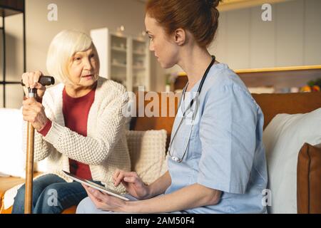 Aufmerksamen jungen Arzt Beratung Ihre ältere Patienten Stockfoto