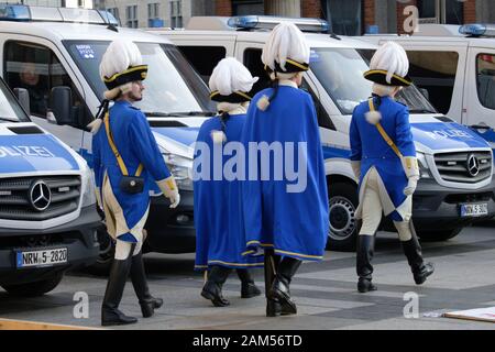 Köln, Deutschland. 11 Jan, 2020. Karnevalisten in blauen und weißen Uniformen vorbei Fahrzeuge der Polizei am Rande einer Kundgebung der deutsch-iranischen Gesellschaft gegen die Verhaftung von Oppositionellen im Iran. Quelle: Henning Kaiser/dpa/Alamy leben Nachrichten Stockfoto