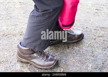 Wanderschuhe werden aufgesetzt und mit Schnürsenkeln getragen, die von älteren Frauen gefesselt werden Stockfoto