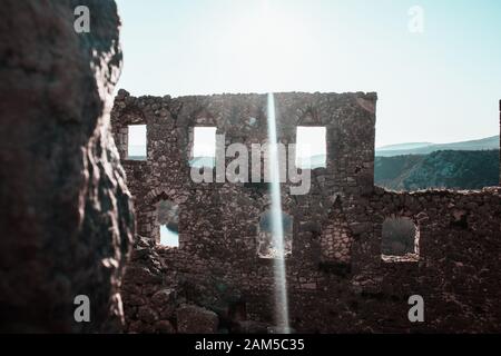 Zerstörte Mauer einer alten Festung in bosnien und herzegowina, pocitelj. Ruinen mit Fensterlöchern, Sonnenschein über das Bild Stockfoto