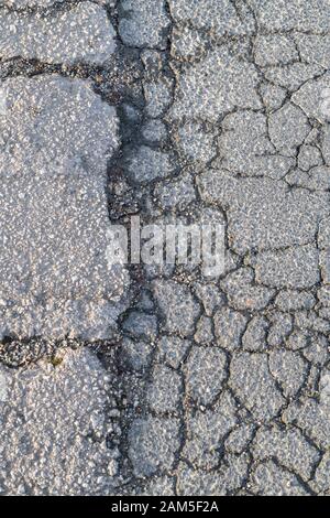 In der Nähe der Kreuzung von zwei Asphaltierten Fußweg Abschnitte, die Brechen. Metapher raue Oberfläche, oben zu knacken, Risse, unebenen Oberfläche. Stockfoto