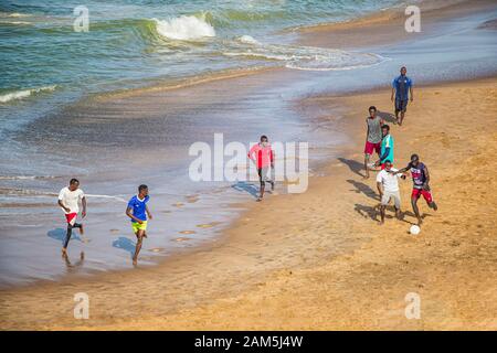 Dakar, Senegal- 24. April 2019: Männer, die am Strand in der Nähe der Stadt Dakar in Afrika Fußball spielen. Sie ist die Hauptstadt des Senegal. Stockfoto