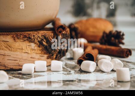 Eine Tasse köstlicher heißer Schokolade und Kakao mit Marshmallows mit Kakaopulver, Kegel und Croissants, Zimt in Grau Stockfoto