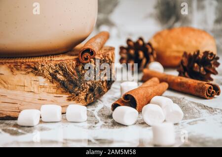 Eine Tasse köstlicher heißer Schokolade und Kakao mit Marshmallows mit Kakaopulver, Kegel und Croissants, Zimt in Grau Stockfoto