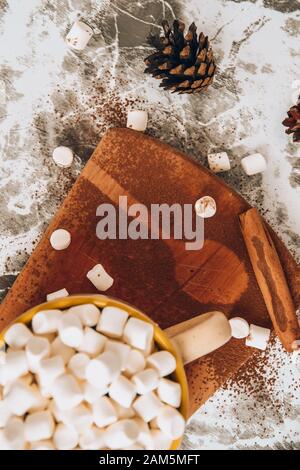 Eine Tasse köstlicher heißer Schokolade und Kakao mit Marshmallows mit Kakaopulver, Kegel und Croissants, Zimt in Grau Stockfoto