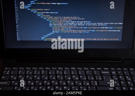 Schließen Sie den CSS-HTML-Code auf dem Monitorbildschirm mit schwarzem Hintergrund Stockfoto