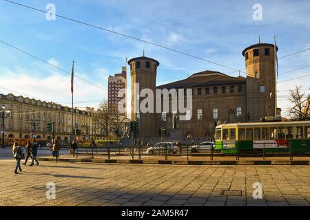 Historische Straßenbahn vor der mittelalterlichen Burg Casaforte degli Acaja mit dem Wolkenkratzer Torre Littoria im Hintergrund, Piazza Castello, Turin, Piemont, Italien Stockfoto