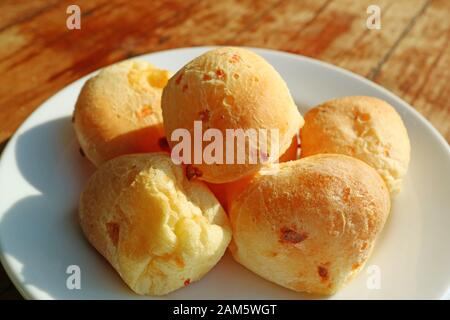 Teller mit Leckerem brasilianischen Käsesorten oder Pao de Queijo Auf Holztisch Serviert Stockfoto