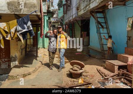 Indische Männer auf der schmalen Straße in Dharavi Slum in Mumbai. Indien Stockfoto