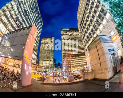 London, England, Großbritannien - Dezembre 11, 2019: Großer Blick auf den Stadtplatz und große Gebäude, die in der Abenddämmerung auf dem Canada Square und Canary Wharf beleuchtet werden Stockfoto