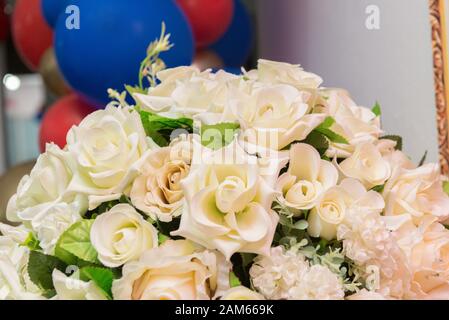 Blumenstrauß auf farbenfrohem Hintergrund. Rosenstrauß Blumen, Blütenblatt mit weißen Rosen. Einrichtung für Kinderparty, Urlaubskonzept. Stockfoto