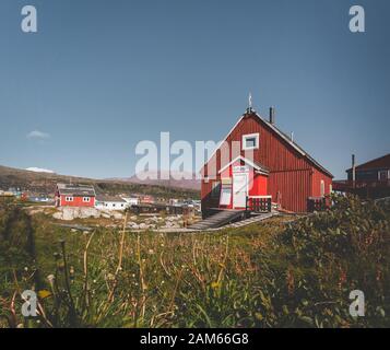 Blick über die bunten Häuser der Diskoinsel Grönland, Arktis Stadt Qeqertarsuaq. In der Disko Bucht. Blauer Himmel und sonnigen Tag. Tabelle Berge Stockfoto