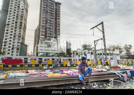 Der indische Mann trocknet Kleidung auf Schienen in der Nähe der Suburban Railway in Dharavi Slum in Mumbai. Indien Stockfoto