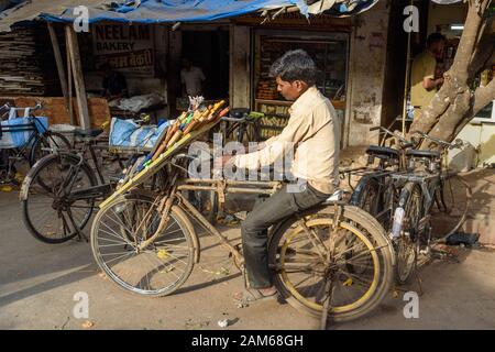 Der indische Mann schärft auf der Straße in Dharavi Slum in Mumbai die Messer auf dem Fahrrad. Indien Stockfoto