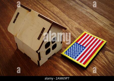 Amerikanische Flagge und kleines Haus. VA Mortgage Loan Konzept. Stockfoto