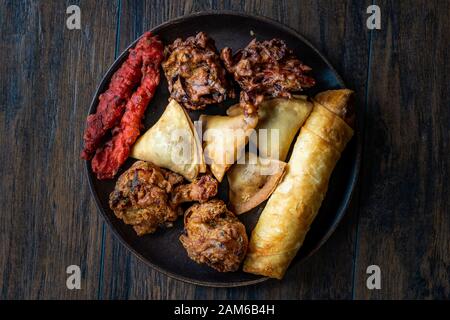 Indisches essen Platte mit Huhn Pakora, Aloo Tikki, Samosas Samsa und Frühlingsrollen. Traditionelle Speisen. Stockfoto