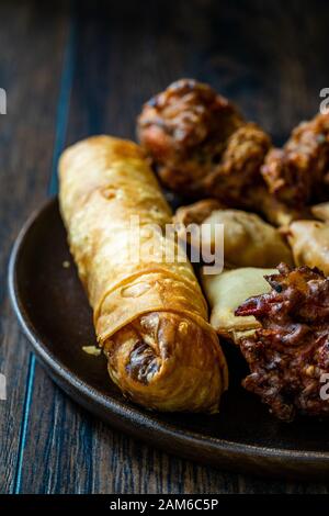 Frühlingsrollen mit Samosas/Samsa mit Huhn Pakora und Aloo Tikki. Traditionelle Speisen. Stockfoto