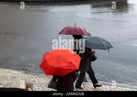 Fußgänger versuchen, sich bei starkem Regen in Coimbra Portugal trocken zu halten Stockfoto