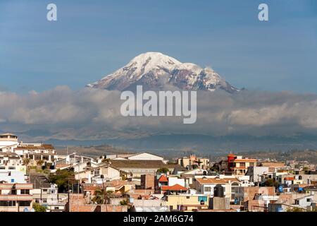 Der Vulkan Mount Chimborazo (6268 m) ist über die Dächer der Stadt Riobamba zu sehen. Stockfoto