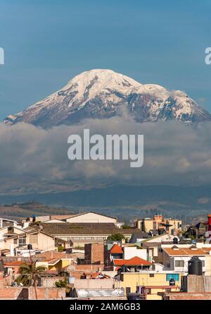 Der Vulkan Mount Chimborazo (6268 m) ist über die Dächer der Stadt Riobamba zu sehen. Stockfoto