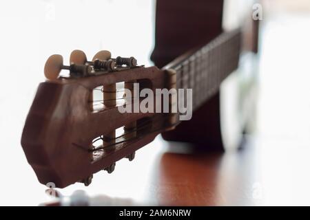 Akustische Gitarre auf Holztisch mit Kopierraum. Selektiver Fokus Stockfoto