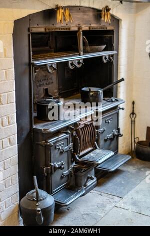 Ein alter Holzofen in einer Küche mit Töpfen und Pfannen Stockfoto