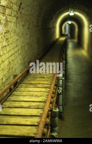 Ein Munitionsförderband, das einen Tunnel hinunterführt, der im zweiten Weltkrieg in Fort Nelson in Portsmouth UK verwendet wurde Stockfoto