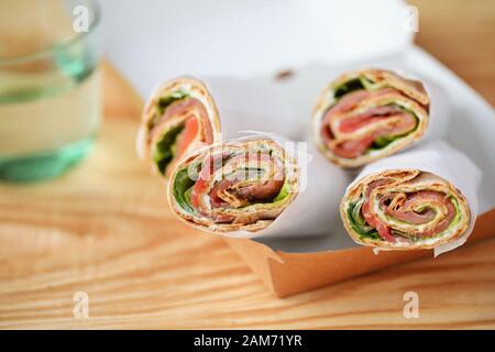 Tortilla-Aufrollungen mit Frischkäse in einer Mitnahmekiste Stockfoto