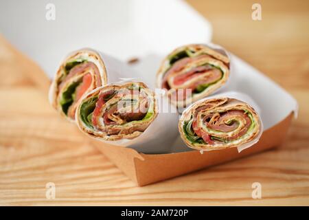 Tortilla-Aufrollungen mit Frischkäse in einer Mitnahmekiste Stockfoto