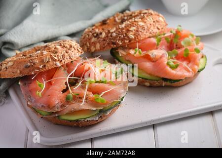 Zwei bagel Sandwiches mit in Scheiben geschnittenen Lachs Salz, Sahne, Käse, Gurken, und Micro Grüns closeup Stockfoto