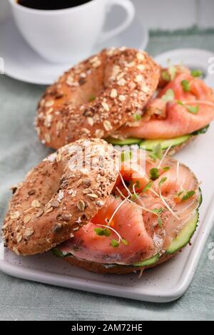 Zwei bagel Sandwiches mit in Scheiben geschnittenen Lachs Salz, Sahne, Käse, Gurken, und Micro Grüns closeup Stockfoto