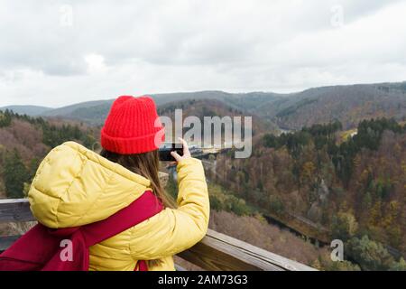 Mädchen stehen auf einem Hügel in der Nähe von einem See in den Bergen, self portrait Stockfoto