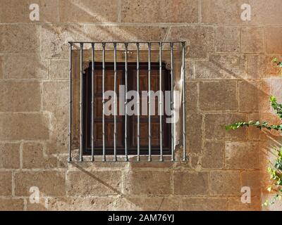 Sicherheitsgitter aus Stahl über dem quadratischen Fenster der Kirche Santa Agueda neben dem Camino de Santiago in Burgos, Baskenland, Spanien Stockfoto