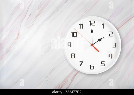 Weiße runde Wanduhr auf natürlichem Marmorhintergrund Stockfoto