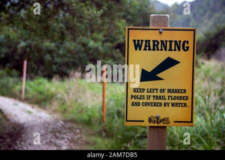 Gehen Sie auf dem Old Ghost Road Trail, Lyell nach Seddonville, Neuseeland. Warnschild in der Nähe der Probenahmehut Stockfoto