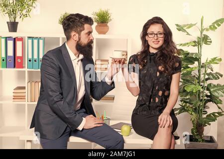 Mann und Frau Gespräch Kaffee Zeit. Büro Gerüchte. Büro Kaffee. Paar Kollegen Kaffeepause entspannen. Teilen Kaffee mit Kollegen. Flirten Kollegen. Mann und attraktive Frau mit Bart. Stockfoto