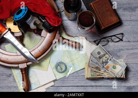 Karte, Kompass, Wein, Geld, Bücher, Schiffsrad, Brille, Messer und Sportgeräte, bereit für ein Reisekonzept Stockfoto