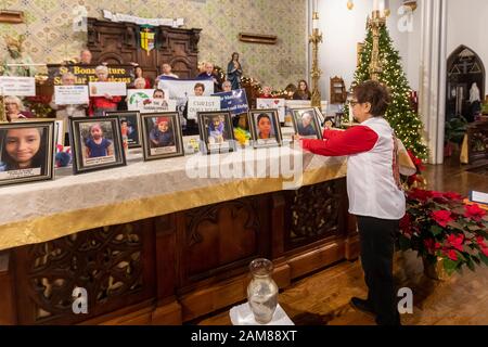 Detroit, Michigan, USA. Januar 2020. Eine "heilige Stunde" in Der Katholischen Dreifaltigkeitskirche unterstützte Flüchtlinge, die vor Gewalt in ihren Heimatländern fliehen. Fotos von Kindern, die während des Aufenthalts in US-Haft nach dem Überschreiten der Grenze starben, wurden auf dem Altar angebracht. Die Veranstaltung wurde von Fremden nicht Mehr während der U.S. Catholic Bishops' National Migration Week organisiert. Kredit: Jim West/Alamy Live News Stockfoto