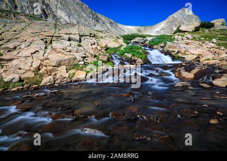 Alpenstrom fließt im Hochland der Colorado Rocky Mountains in der Indian Peaks Wilderness im Sommer durch Felsen Stockfoto