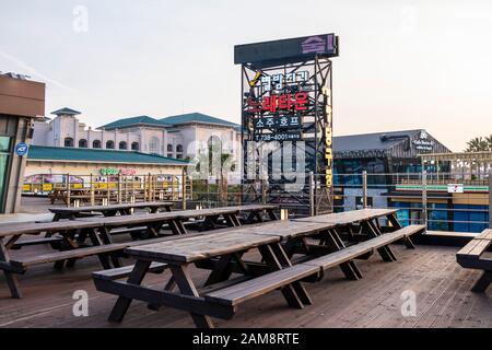 Jeju, Korea, 6. März 2019. Holzstühle und Schreibtische vor dem Restaurant BHC Chicken. Stockfoto