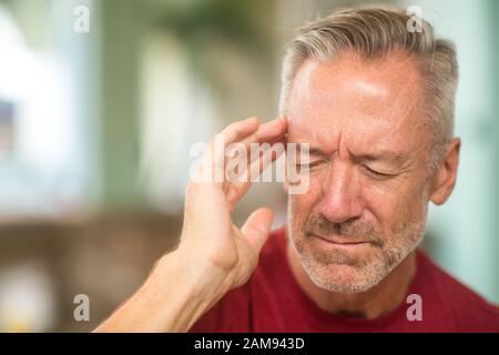 Reifer Mann mit einem Kopfschmerzen Foto Stockfoto